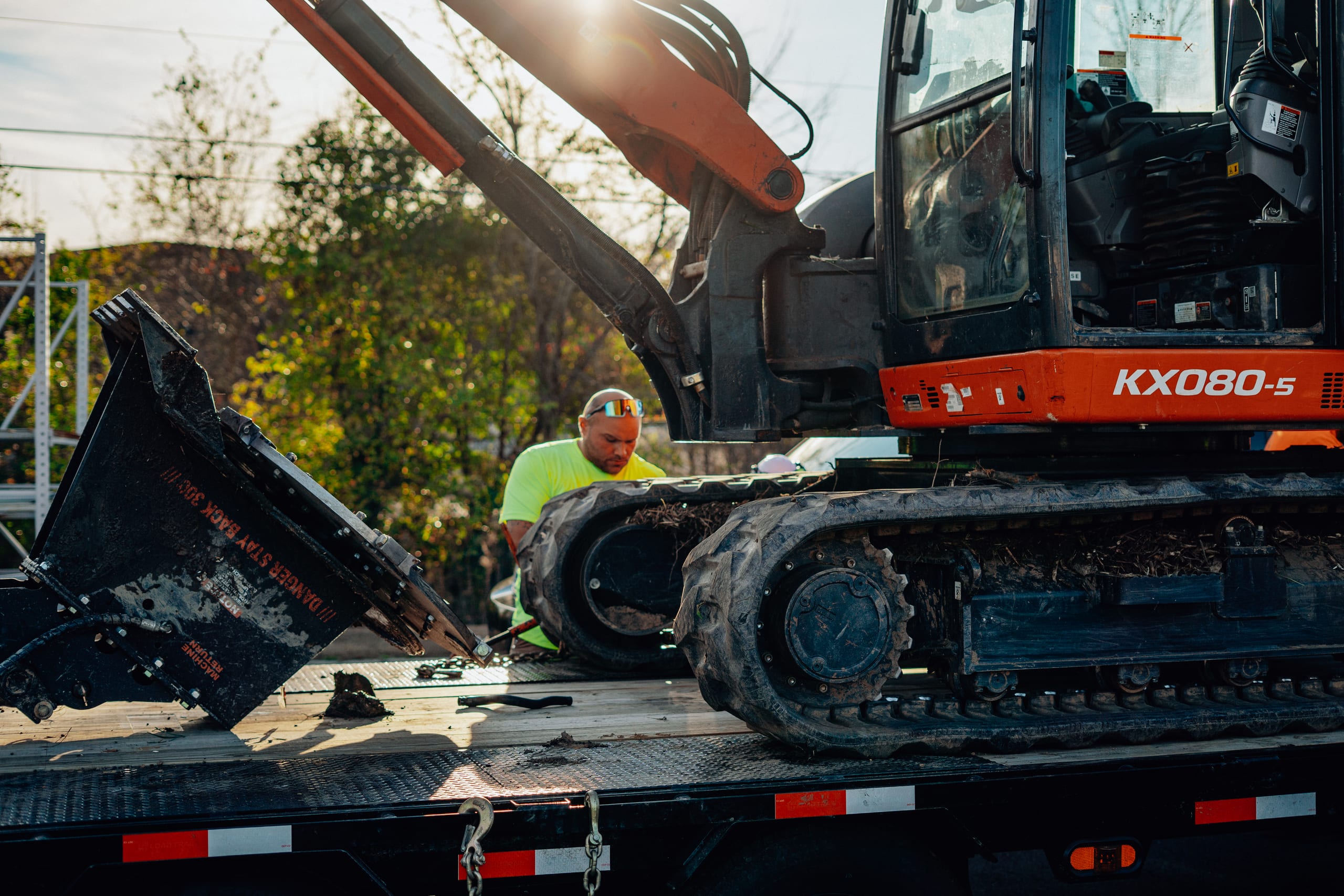Addison Excavations team member standing with heavy equipment